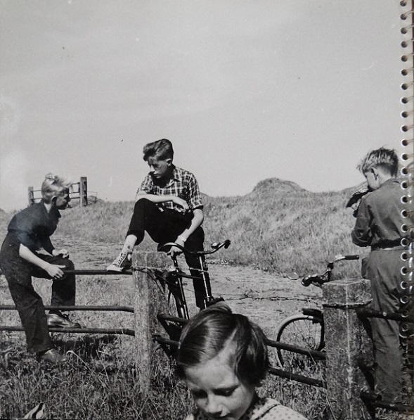 m 047 jongens, kletsend bij een dijk. Een met gympen, een ander in overall.